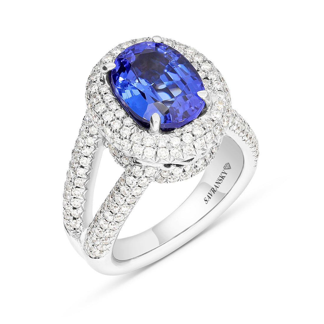 A stunning Oval shape Blue tanzanite set into double Halo diamond and leading to a cathedral pave band. 